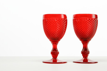 Two red empty wine glasses on a white background and white table. Copy space