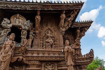 The intricate wooden architecture of the Temple of Truth in Pattaya,Thailand.The temple features ornate carving and statues,with a detailed root structure and multiple spires.outside view