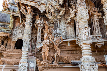 The intricate wooden architecture of the Temple of Truth in Pattaya,Thailand.The temple features ornate carving and statues,with a detailed root structure and multiple spires.outside view
