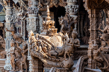 The intricate wooden architecture of the Temple of Truth in Pattaya,Thailand.The temple features ornate carving and statues,with a detailed root structure and multiple spires.outside view