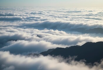 Fototapeta premium Vast layers of soft, white clouds cover rugged mountain peaks, creating a tranquil and serene atmosphere illuminated by subtle morning light.