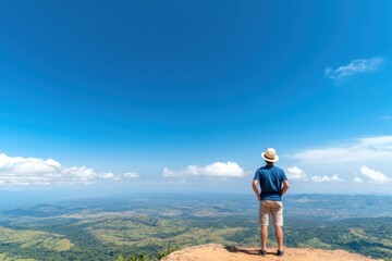 Obraz premium Man Enjoying Scenic View from Mountain Peak Under Clear Blue Sky