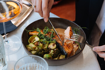Grilled salmon with brussels sprouts and broccoli served for a dinner in a restaurant.	