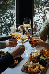 Friends having a dinner party with different kinds of appetizers and wine.