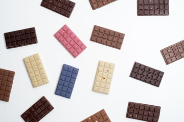 Multicolored chocolate bars placed on a light background. Healthy eating concept, delicious...