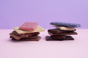 Multicolored chocolate bars placed on a light background. Healthy eating concept, delicious chocolate candies, diet, sugar
