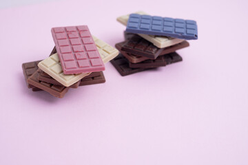 Multicolored chocolate bars placed on a light background. Healthy eating concept, delicious...