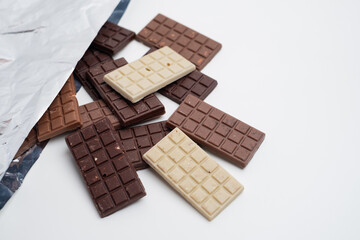 Multicolored chocolate bars placed on a light background. Healthy eating concept, delicious...