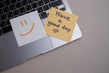 Piece of paper with the inscription Have a good day and a piece of chocolate on the table. Warm...