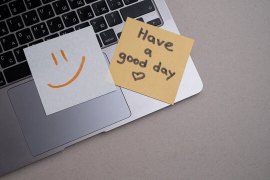 Piece of paper with the inscription Have a good day and a piece of chocolate on the table. Warm wishes