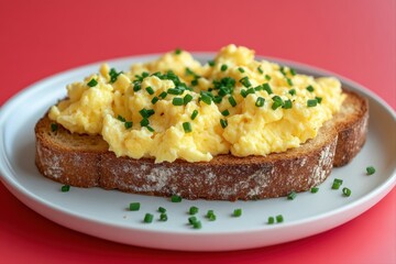 Scrambled Eggs on Toast. A delightful dish of soft scrambled eggs generously placed on toasted bread, sprinkled with fresh chives.