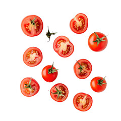 Scattered arrangement of cut and whole cherry tomatoes on a solid black background overhead view flat lay