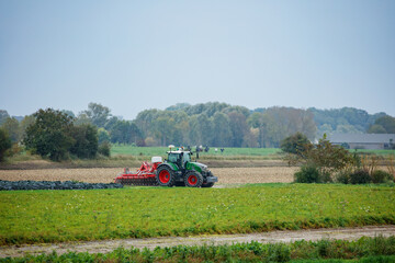 Obraz premium Tractor is seen cultivating the autumn field in Normandy, France