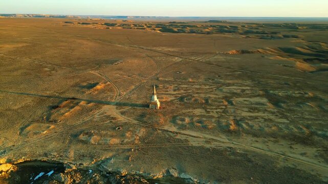 drone video flyby of a small lonely tower in the rays of sunset on a deserted cliff shpak kazakhstan mansgystau