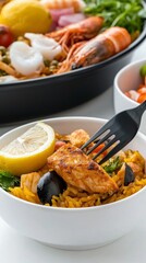 Delicious Seafood Paella with Lemon Wedge on Clean White Background