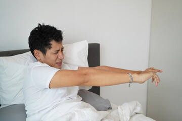Sleepy man stretching arms forward