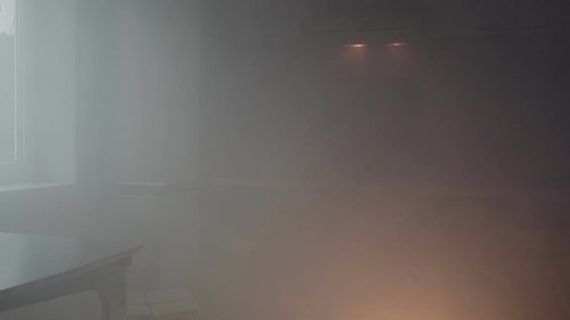 Thick smoke fills a dimly lit kitchen, indicating a severe fire hazard with glowing flames visible, creating an urgent and dangerous atmosphere