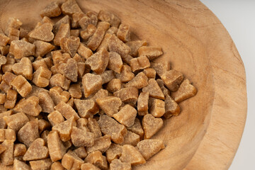 Mini pet food shaped like hearts in bowl close up, small dogs crunchy treats pile macro