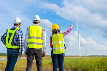 Three engineers working in the clean energy and wind sectors are seen discussing industry projects,...
