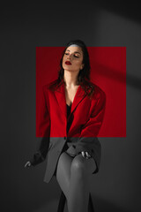 Young Woman In Red Suit With Red Lips Posing On The Red Background