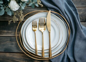 Elegant table setting with gold cutlery and plates on a wooden surface, top view flat lay