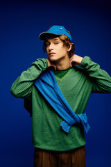 Young man displays vibrant fashion trends with stylish accessories in a studio