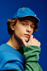 Young man showcases stylish outfit with striking colors against a vivid backdrop