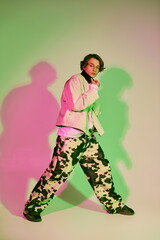 Dynamic young man in vibrant studio, showcasing contemporary fashion and unique style