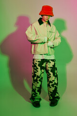 Young man showcases modern fashion style with vibrant colors and playful patterns at a studio shoot