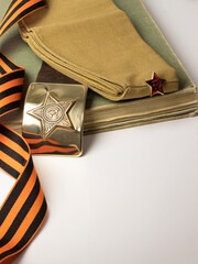 St. George ribbon, Soviet Union soldier's belt with star, hammer and sickle on buckle on white background. Blank for postcard for Victory Day on May 9.