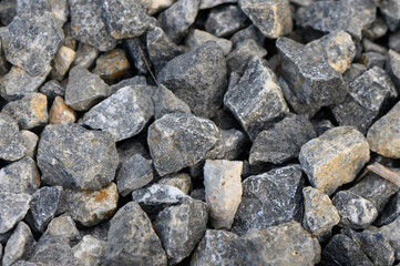 Natural gray gravel aggregate creates a sturdy foundation for landscaping and construction in a sunny outdoor setting