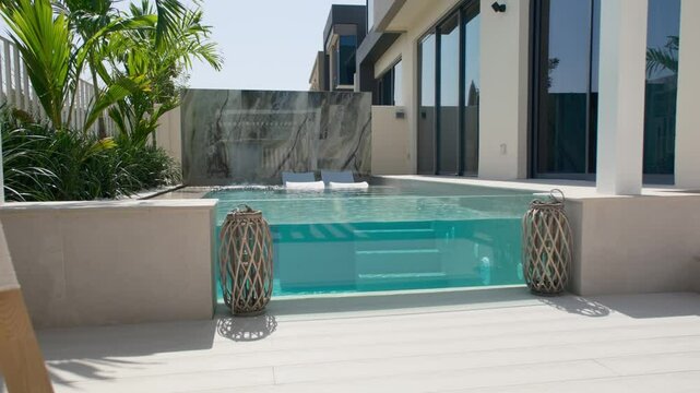 A small private swimming pool in the backyard of a luxury villa in Dubai on a sunny day