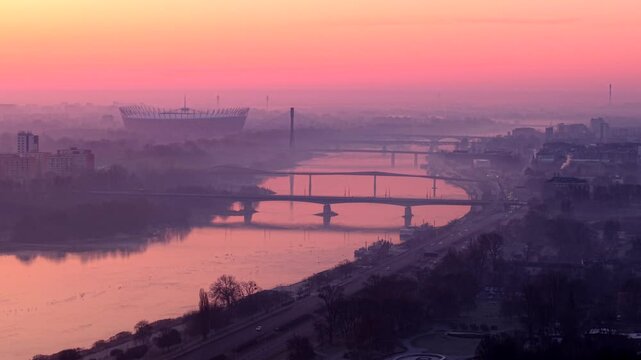 Misty sunrise over the Vistula river with bridges and PGE Narodowy stadium in Warsaw