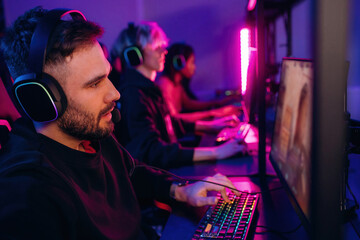 In headphones. Gamers are playing video game by computers