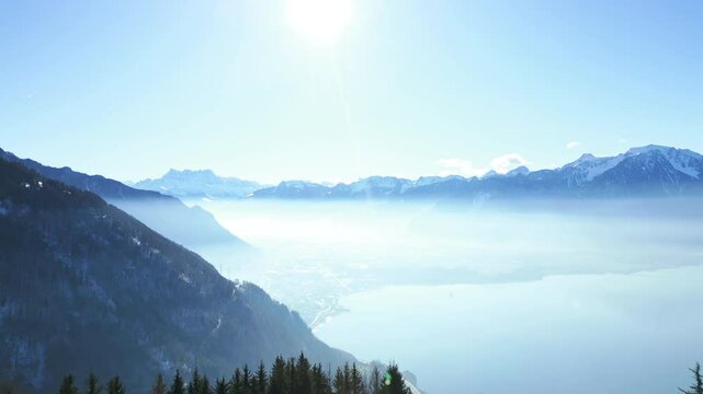 Aerial: landscape from Caux Palace Hotel of Lake Geneva and Dents du Midi mountain range in Caux, canton of Vaud, Switzerland, push in drone shot