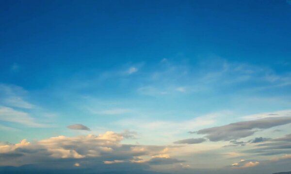 Langit biru dan awan putih yang bergerak saat matahari cerah 
