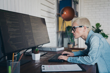 Focused young professional working on coding projects in a modern home office workspace