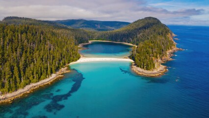 Obraz premium Landscape of a forest-covered peninsula jutting into a lake, with ocean views and a rocky shoreline.