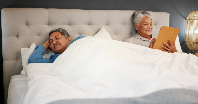 Senior couple, bed and tablet in home for communication, scroll or reading news. Retirement, man and woman with technology in bedroom for internet addiction, puzzle game and partner sleeping at night