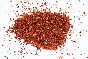 Pile of crushed chili peppers on white background top view