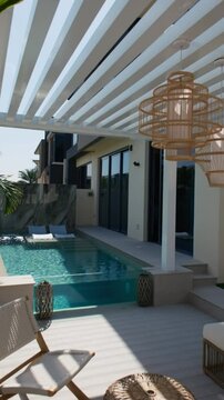 Small swimming pool with canopy and sofa in the backyard of a private villa in Dubai on a sunny day