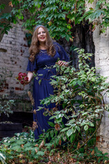 Woman in a long blue dress in the garden.