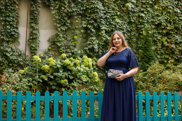 Woman in a long blue dress in the garden.