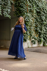 Naklejka premium Woman in a long blue dress in the garden.