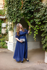 Woman in a long blue dress in the garden