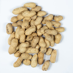 Pile of unpeeled peanuts in shell close-up on white background.
