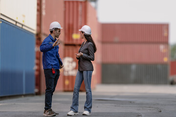 Obraz premium Foreman worker wear safety hardhat standing inspecting container cargo at warehouse storage terminal. Industrial engineer woman working at import export distribution port. Diverse people work together