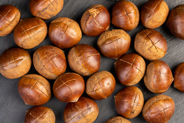 preparation by cutting the shells of edible chestnut nuts for baking, closeup, top view