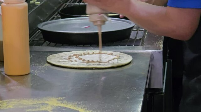 Chef's hands kneading dough on the cooking table, cooking pizza