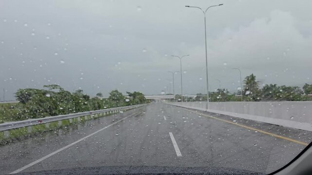 driving on a rainy day, the wiper sweeps away the rainwater on the windshield of the car